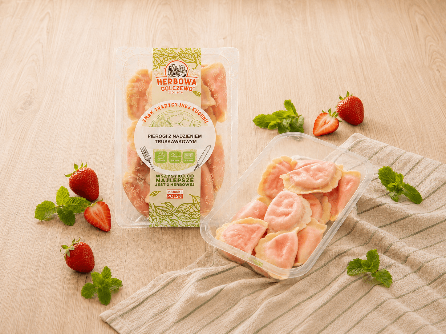 Pierogi z kawałkami truskawek Herbowa — zestawienie zamkniętego i otwartego przezroczystego opakowania z dodatkami zgodnymi ze składem.