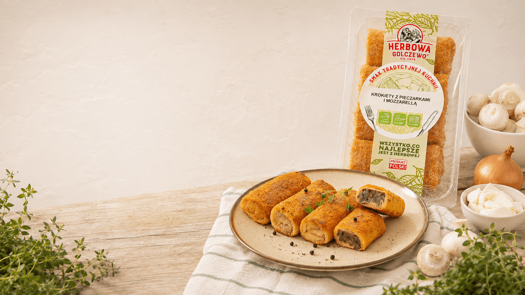 Krokiety z pieczarką i mozzarellą Herbowa na talerzu, z opakowaniem i składnikami na jasnym stole.
