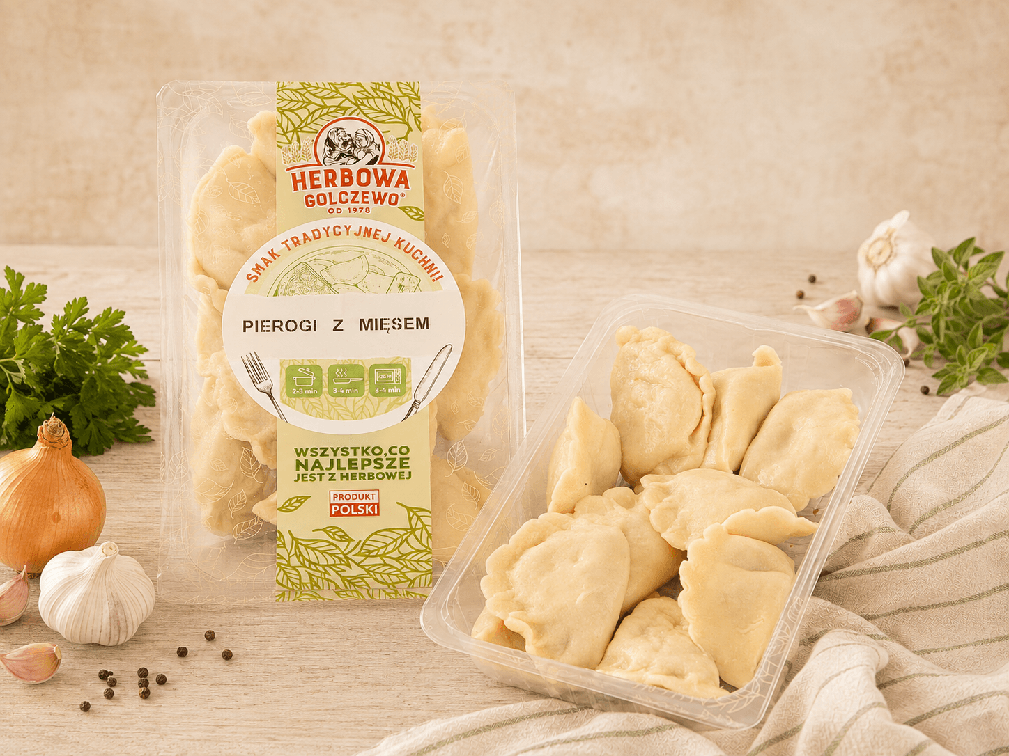 Pierogi z mięsem i dodatkiem wołowiny Herbowa — zestawienie zamkniętego i otwartego przezroczystego opakowania z dodatkami zgodnymi ze składem.