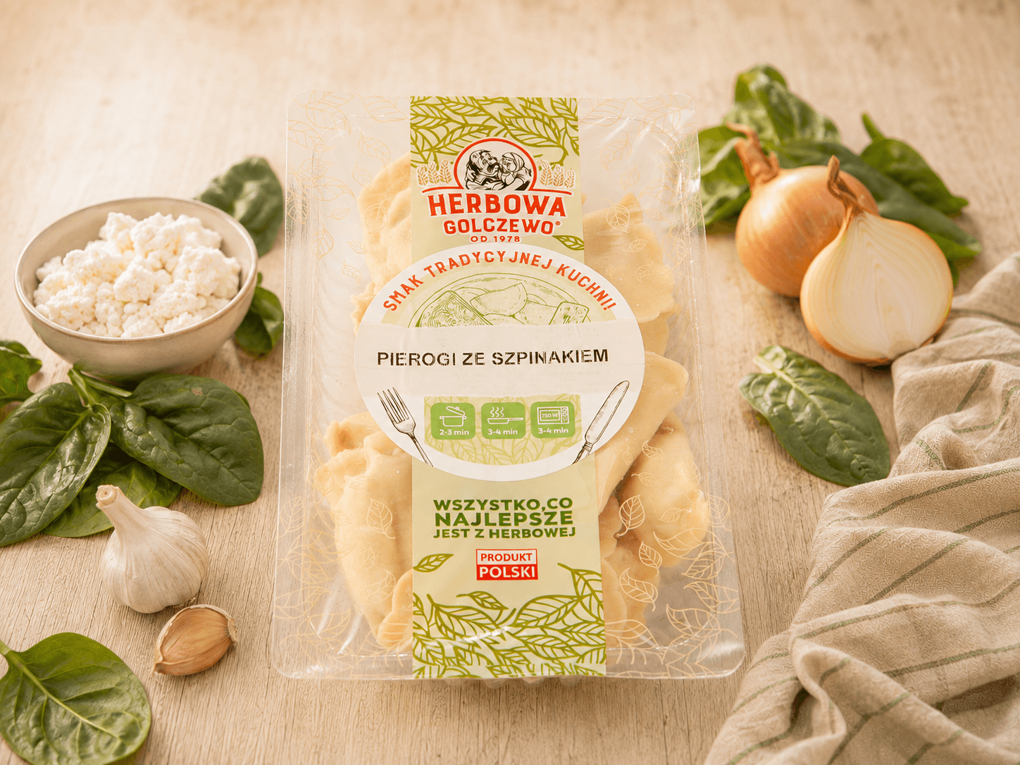 Pierogi ze szpinakiem Herbowa — zamknięte przezroczyste opakowanie z dodatkami zgodnymi ze składem.