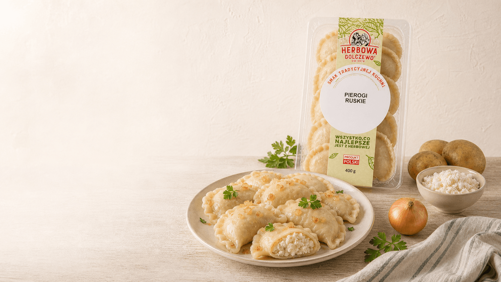 Pierogi ruskie Herbowa — wizualizacja tymczasowa podania i opakowania, przygotowana bez rzeczywistego zdjęcia produktu. Do zastąpienia po dostarczeniu fotografii.