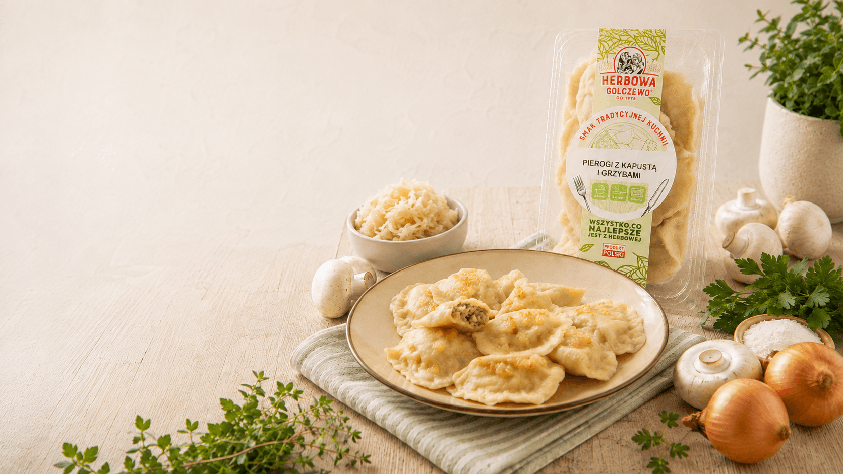 Pierogi z kapustą i grzybami Herbowa na talerzu, z opakowaniem i składnikami na jasnym stole.