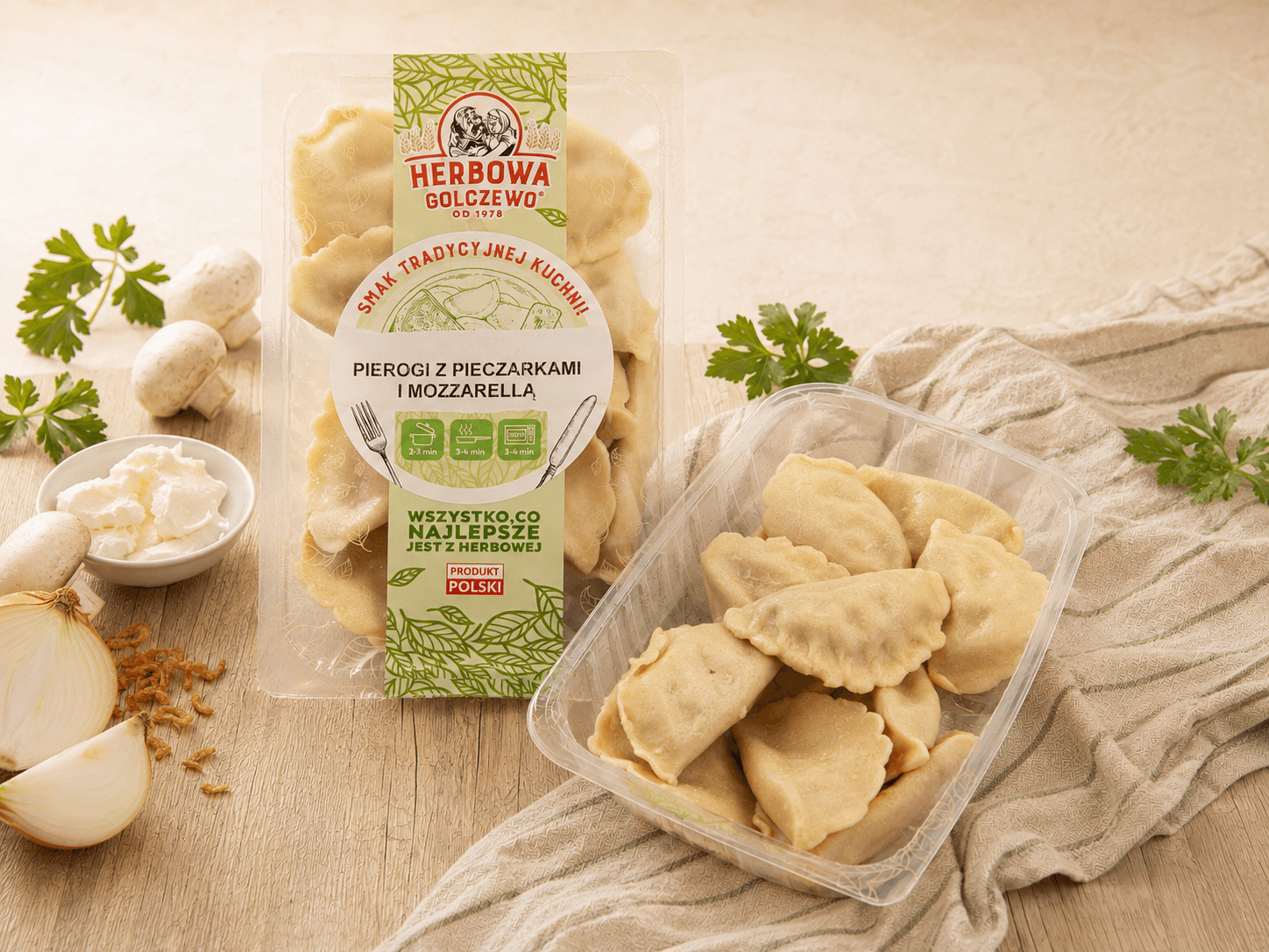 Pierogi z pieczarką i mozzarellą Herbowa — zestawienie zamkniętego i otwartego przezroczystego opakowania z dodatkami zgodnymi ze składem.